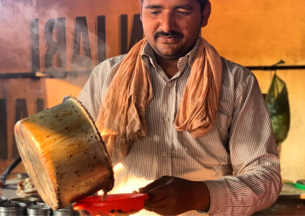 A dhaba owner pouring steaming hot masala chai